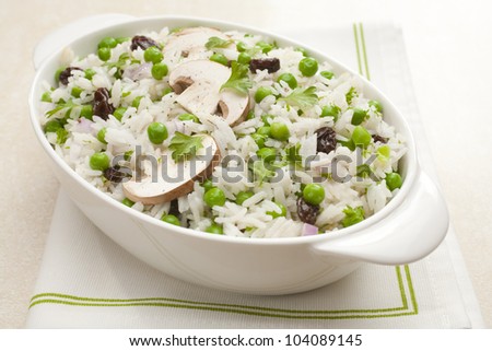 Rice salad with peas and mushrooms. Vinaigrette is added to hot cooked rice along with raisins, when cool peas, mushrooms, onion and parsley are added.