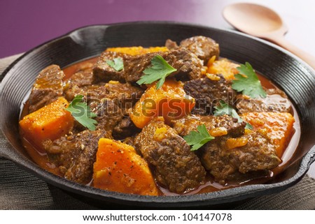 Moroccan tagine or stew of beef with sweet potato, in a cast iron pan.