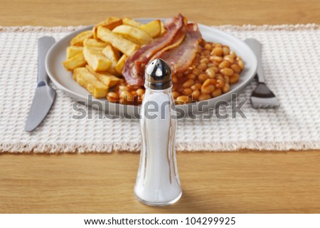 What not to eat - salt, in front of a typical high salt, high fat meal of chips, bacon and baked beans.
