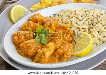 An Indian meal of chicken tikka masala and pilau rice, with naan bread on the side. Britain\'s favourite curry, more popular than fish and chips,