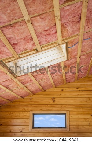 Fibreglass insulation installed in the sloping ceiling of a timber house.