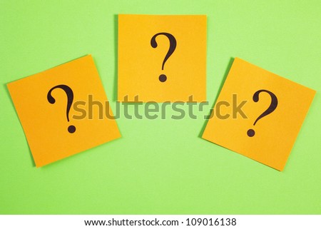 Any questions? Three question marks on orange, on a green background.