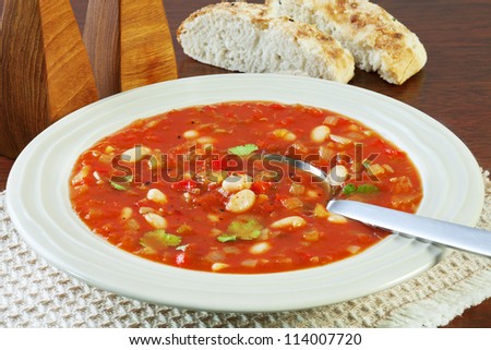 A bowl of vegetable soup with tomato and white beans. Perfect for a cold winter night!