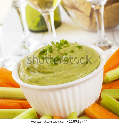 Guacamole topped with fresh green chilli, with carrot and celery sticks for dipping.