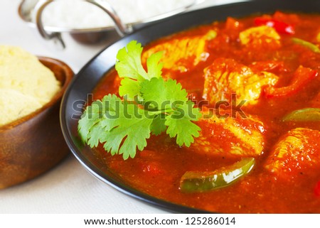 Chicken Jalfrezi with rice and poppadums. This curry was invented by Indian chefs in the time of the Raj, when left over roast chicken would have been combined with spices and vegetables.