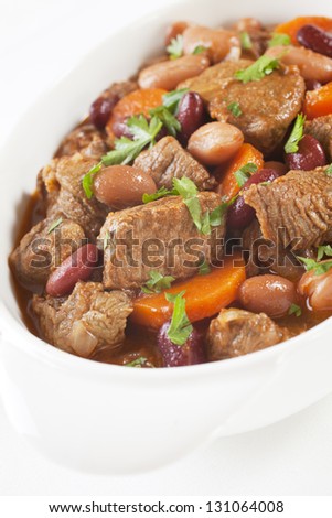 A simple bowl of stew with carrots and beans.