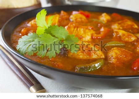 Chicken Jalfrezi with rice and poppadums. This curry was invented by Indian chefs in the time of the Raj, when left over roast chicken would have been combined with spices and vegetables.
