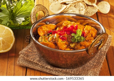 Chicken curry in a balti dish, with mini poppadums, salad and lemon.