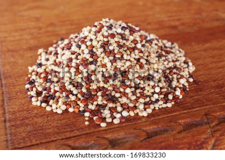 Quinoa and Amaranth - ancient grains quinoa and amaranth in a pile on a wooden board. Quinoa contains white, red and black grains.