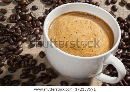 Espresso Coffee and Coffee Beans - a cup of espresso on a rustic background with coffee beans. Focus on coffee.