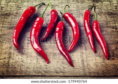 Red Chillies on Rustic Background - seven red chillies on a plank or rustic background, with an instagram effect.