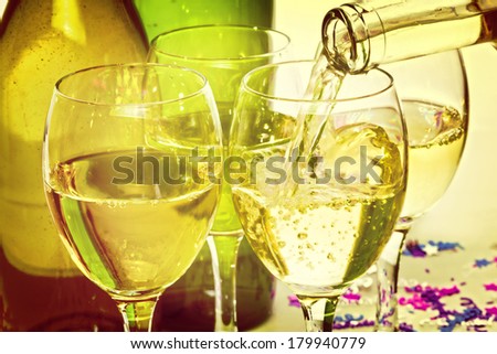 White Wine Pouring into Glasses - white wine being poured into glasses at a party, with an instagram effect.