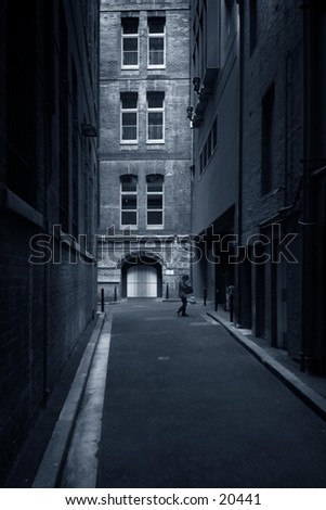 Side street with buildings at sides,  woman at door in distance, blue tone.