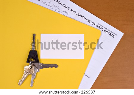 Blank business card sitting on yellow folder with contract inside it. Keys on top, waiting for real estate person's details.