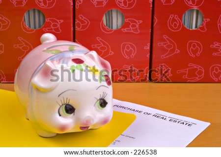 Piggy bank on top of real estate contract, yellow folder, red magazine files behind.