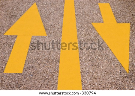 Two arrows painted on a road, pointing in opposite directions