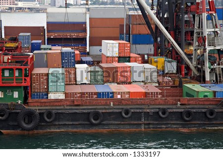 Stock photo of shipping containers on board lighters at a container terminal on Victoria Harbour Hong Kong, stacked containers in background.