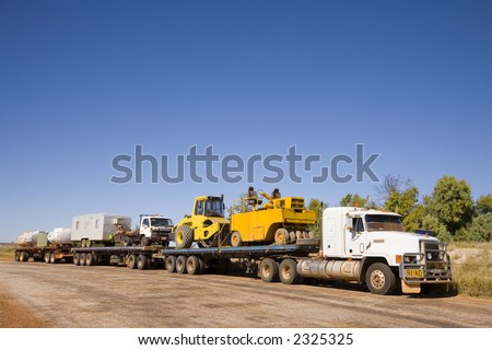 Road train in outback Northern Territory, Australia, in a rest area, carrying road construction equipment.