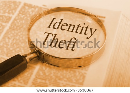 Dictionary with magnifying glass emphasising the words Identity Theft, something which is a concern to all in the age of the internet.