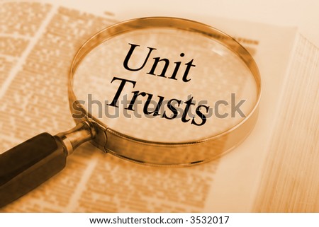 Dictionary with magnifying glass emphasising the words Unit Trusts. SEe others from this series in our portfolio.