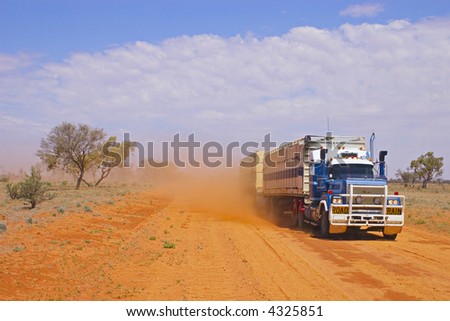 Road train in outback Queensland, Australia, kicking up dust.