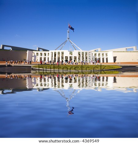 Parliament House, Canberra, Australia, with a large group of tourists outside, Australian flag flying. Photoshop reflection has been matched as closely as possible to real reflection.