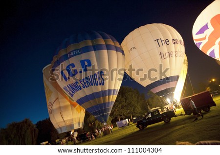 NORTHAMPTON, ENGLAND - AUGUST 18: Hot Air Balloons in night time burn demonstration at the Northampton Balloon Festival, on August 18, 2012 in Northampton, England.