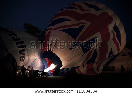 NORTHAMPTON, ENGLAND - AUGUST 18: Hot Air Balloons inflating at night  at the Northampton Balloon Festival, on August 18, 2012 in Northampton, England.