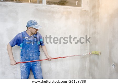 master inflicts layer a glue for wallpaper on wall