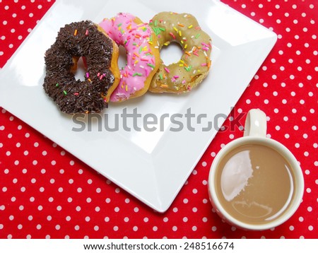 donut and milk coffee on red tablecloth