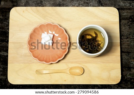 Tea water and wood spoon decorate on wood.