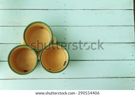 Three vintage cup decorated on green table for background.