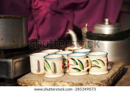 Tea cups , pan on stove and kettle at street market stall