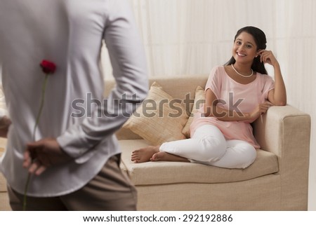 Beautiful Indian woman looking at man while relaxing on sofa