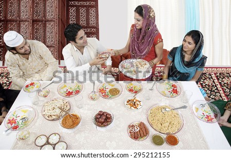 Muslim woman serving food during Id