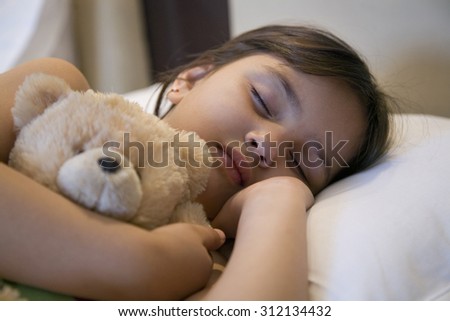 Girl sleeping with a stuffed toy