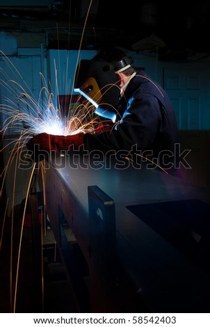 Welder in fabrications factory constructing a metal box section.
