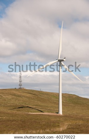 Wind turbine on a wind farm in Scotland, Europe close to a mobile phone transmitter mast.