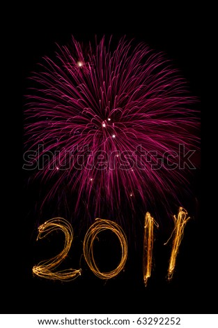 New Year celebration sparklers writing 2011 below pink fireworks against black background.