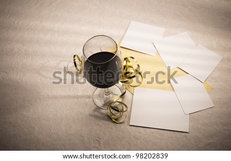 Glowing wine glass, decorations, invitation card and blank photograph frames. These spaces can be used to add images and invitation text as required. There is copy space at the left for plenty of text