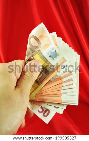 Hand presenting a large amount of money