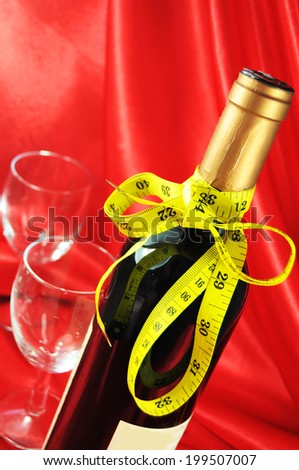 drinking with measure concept with bottle of wine, glasses and measuring tape