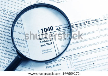 Tax forms investigation concept with magnifying glass and 1040 US Income Tax Return