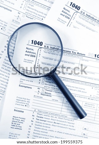 Tax forms investigation concept with magnifying glass and 1040 US Income Tax Return