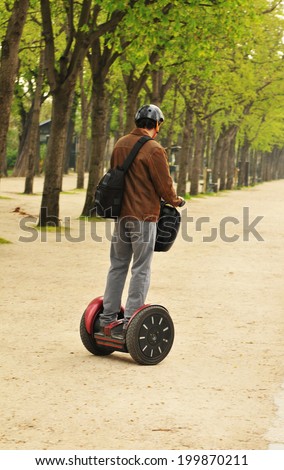 PARIS, FRANCE - MARCH 30, 2011: Young man with ecological mean of transportation in Les Jardins de Tuilleries.