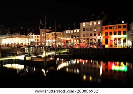 COPENHAGEN, DENMARK - DECEMBER 18, 2011: Night view of old architecture and boats on Nyhavn, a 17th-century waterfront, canal and entertainment district in Copenhagen, Denmark.