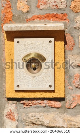Retro ring bell against weathered wall in Venice, Italy