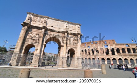 ROME, ITALY - MARCH 30, 2012: Tourists visit the famous Arch of Constantine, a triumphal monument in Rome, situated between the Colosseum and the Palatine Hill.