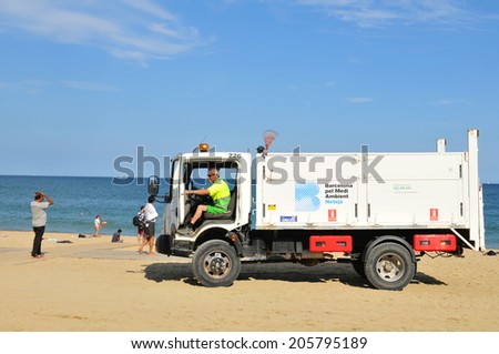 BARCELONA, SPAIN - JULY 6, 2012: Garbage crew is cleaning the beaches in Barceloneta, Spain
