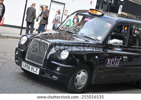 LONDON, UK - AUGUST 23, 2010: Old-fashioned black taxi drives on the streets of central London